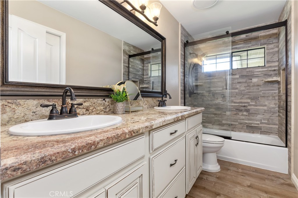 1275 Shane Lane Templeton, CA 93465 - Photo 42 of 70 a bathroom with a granite countertop sink a toilet a mirror and shower