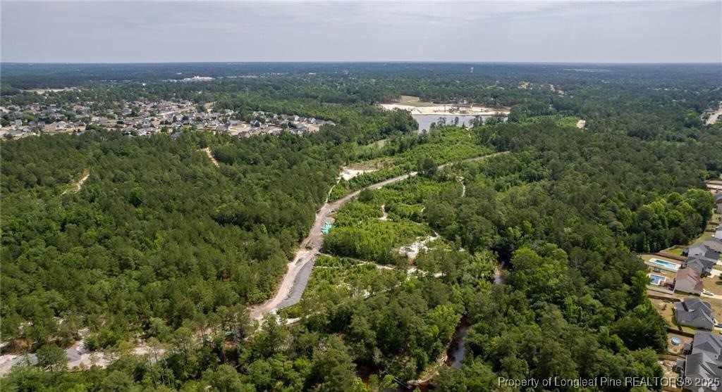5869 Permastone Lake Road Hope Mills, NC 28348 - Photo 2 of 7 an aerial view of residential houses with outdoor space and trees