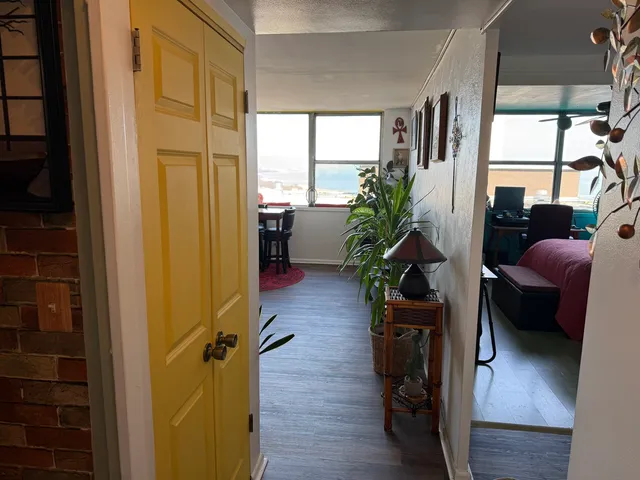 a living room with furniture floor to ceiling window and wooden floor