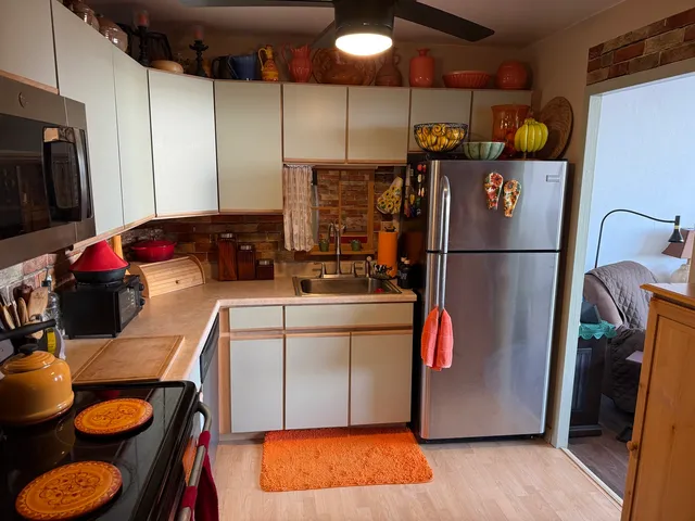a kitchen with a refrigerator sink and cabinets