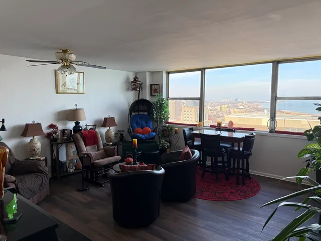 a living room with furniture a fireplace and large windows