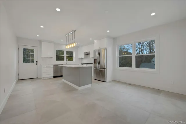 a view of a kitchen with a sink and dishwasher a refrigerator with wooden floor