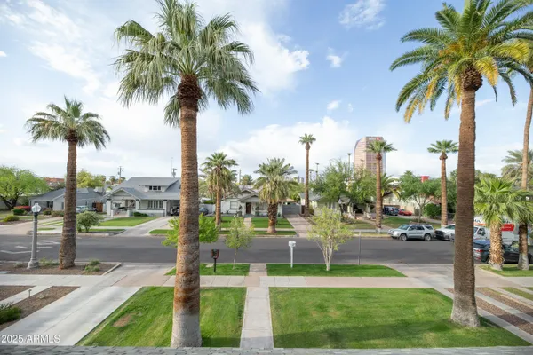 an empty room with wooden floor ceiling fan and windows