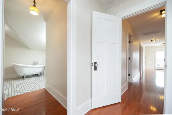 a view of empty room with wooden floor and fan