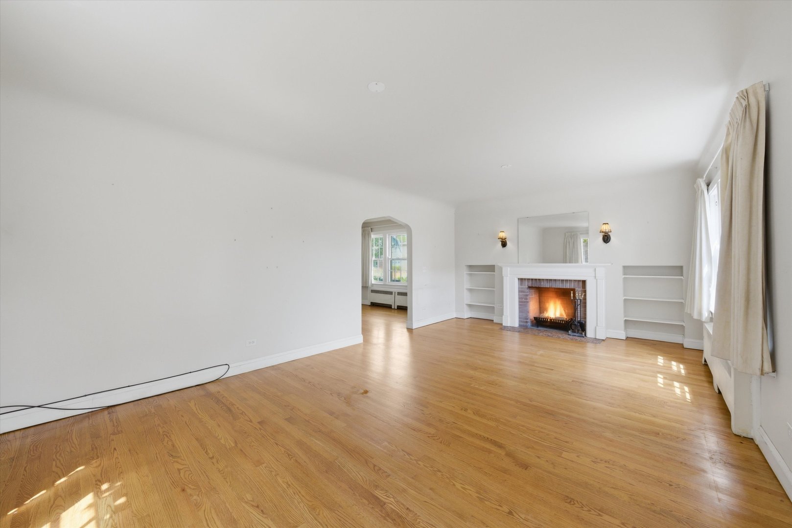 3100 Clinton Avenue Berwyn, IL 60402 - Photo 4 of 25 a view of an empty room with wooden floor fireplace and a window