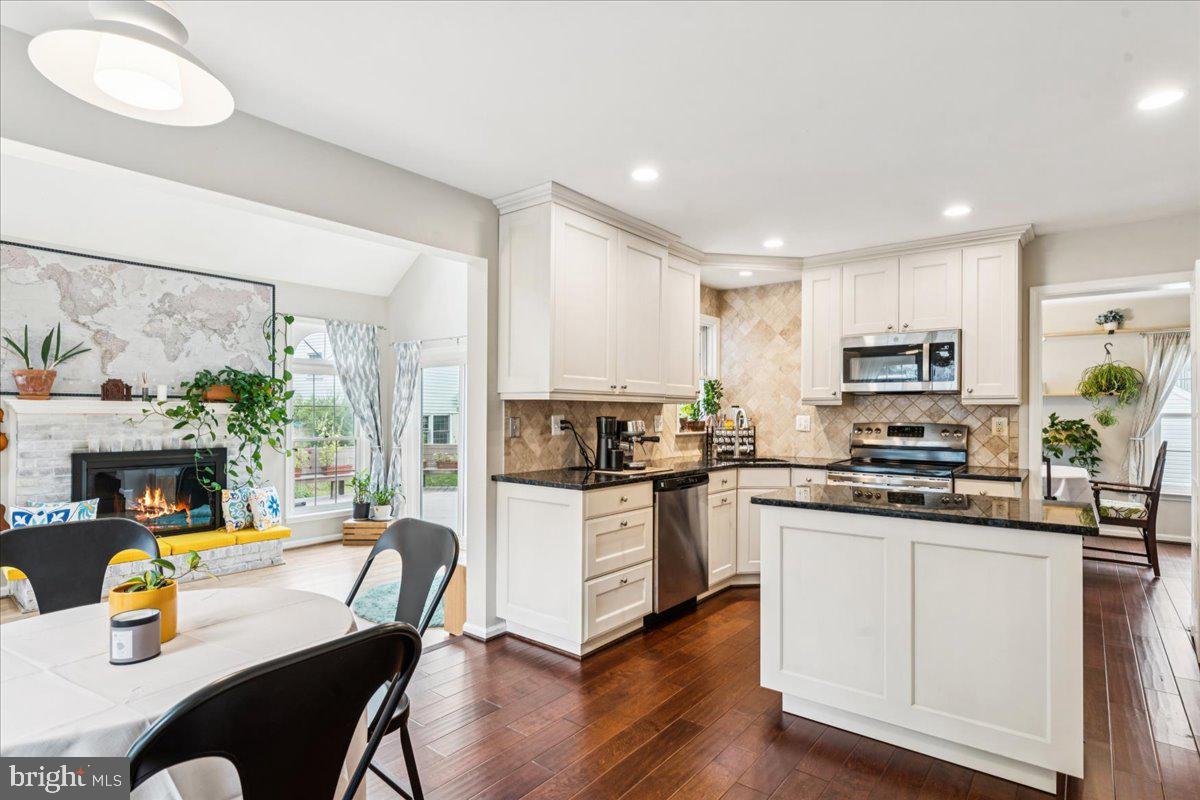 12592 Rock Ridge Road Herndon, VA 20170 - Photo 11 of 41 a kitchen with stainless steel appliances granite countertop a stove top oven a sink a dining table and chairs