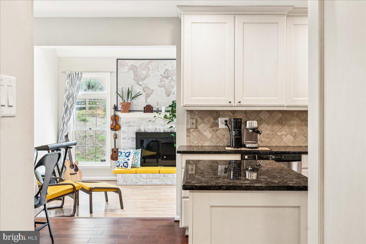 12592 Rock Ridge Road Herndon, VA 20170 - Photo 12 of 41 a kitchen with granite countertop a stove a sink and white cabinets with wooden floor