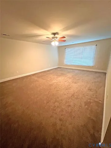 en empty room with windows and fan