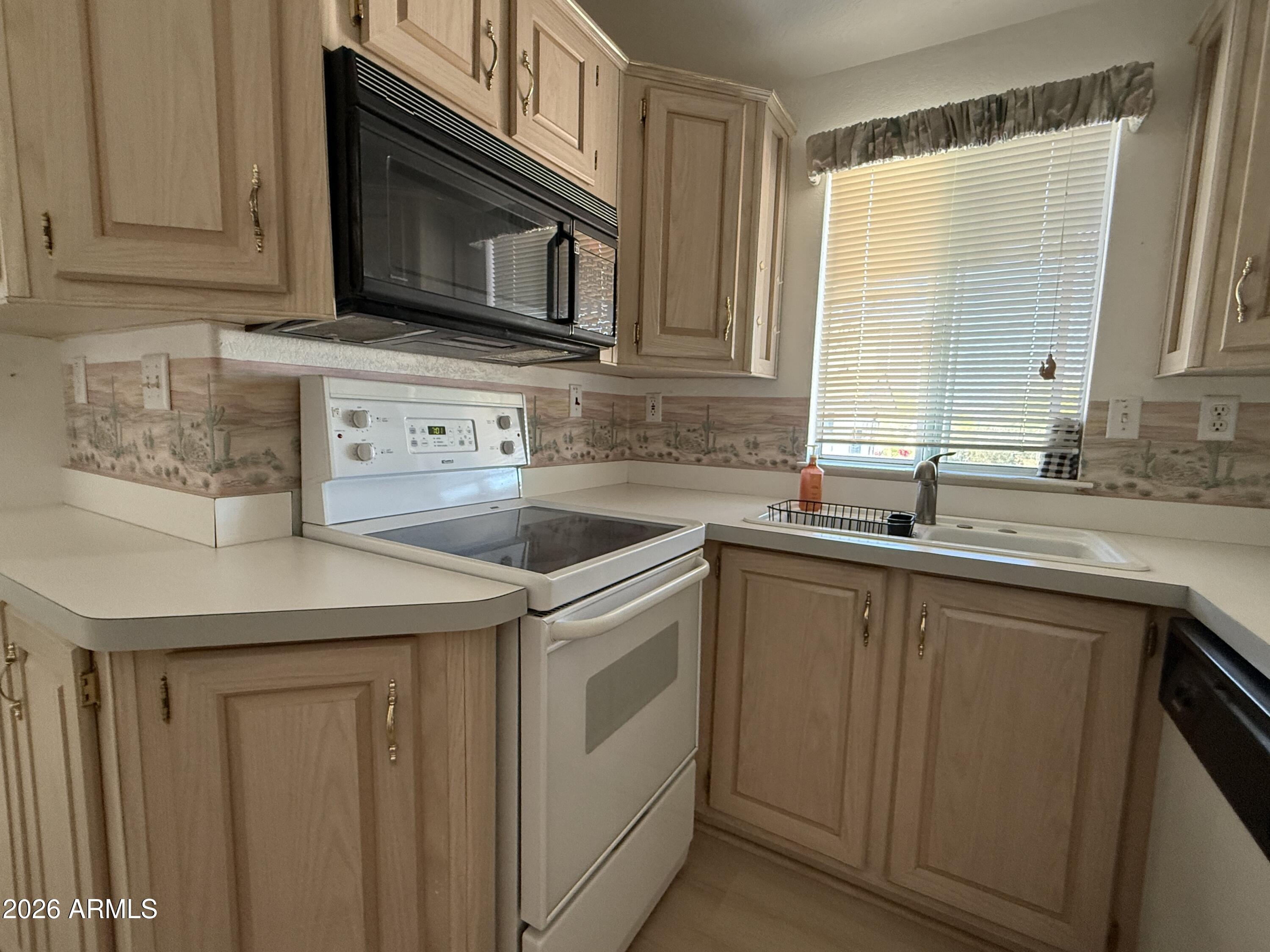 21340 Trading Post Trail Congress, AZ 85332 - Photo 11 of 31 a kitchen with stainless steel appliances granite countertop a sink stove and microwave