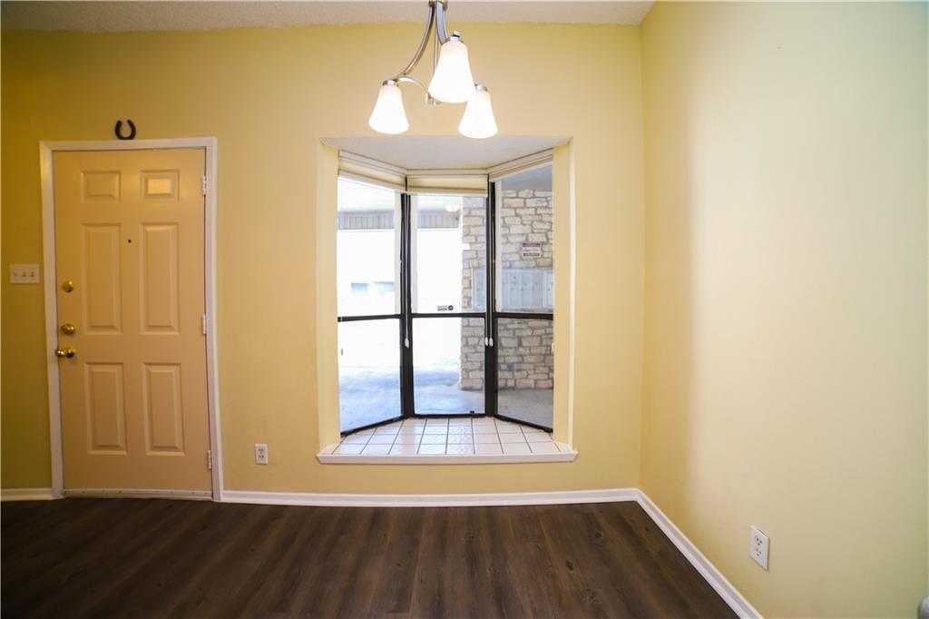 2604 Salado Street, Unit 103 Austin, TX 78705 - Photo 2 of 6 Unfurnished dining area with dark wood-style floors and a chandelier