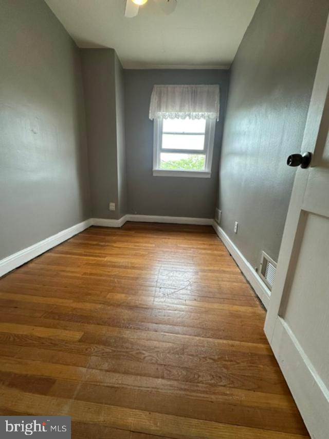 1619 Inverness Avenue Baltimore, MD 21230 - Photo 22 of 30 a view of an empty room with wooden floor and window