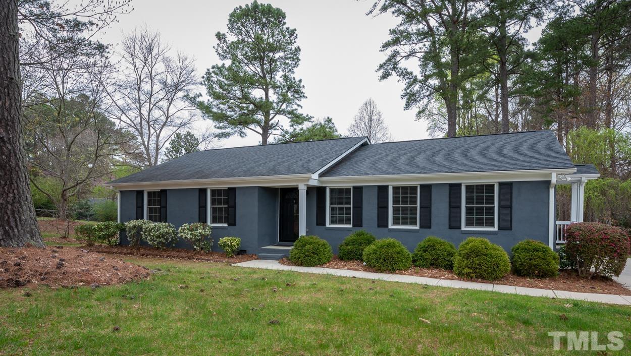 a view of a house with a yard and potted plants large tree