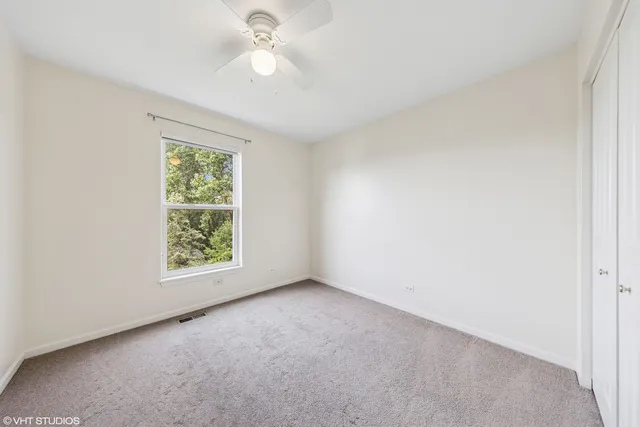 an empty room with a window and a fan
