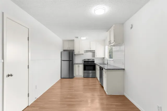 a kitchen with stainless steel appliances granite countertop a refrigerator and a sink