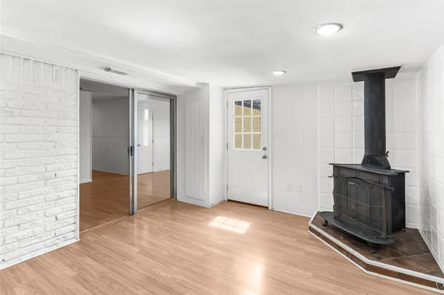 an empty room with wooden floor and a fireplace