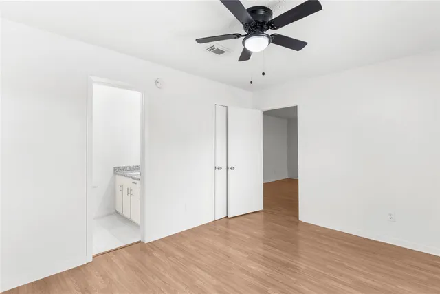 a view of a big room with wooden floor and a ceiling fan