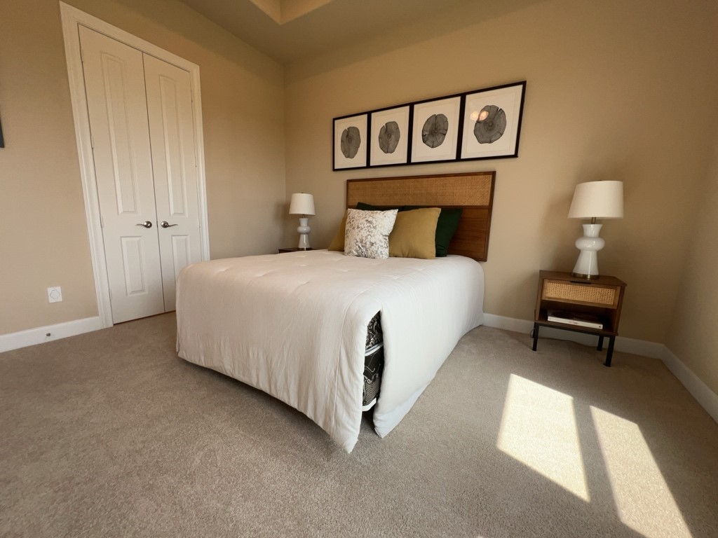 5602 Caracara Street Manvel, TX 77578 - Photo 14 of 27 a bedroom with a bed and a lamp on table