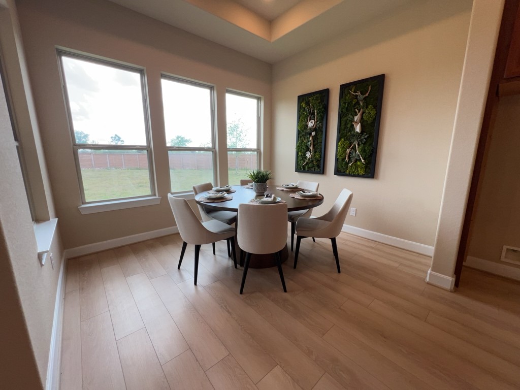 5602 Caracara Street Manvel, TX 77578 - Photo 8 of 27 a view of a dining room with furniture and wooden floor