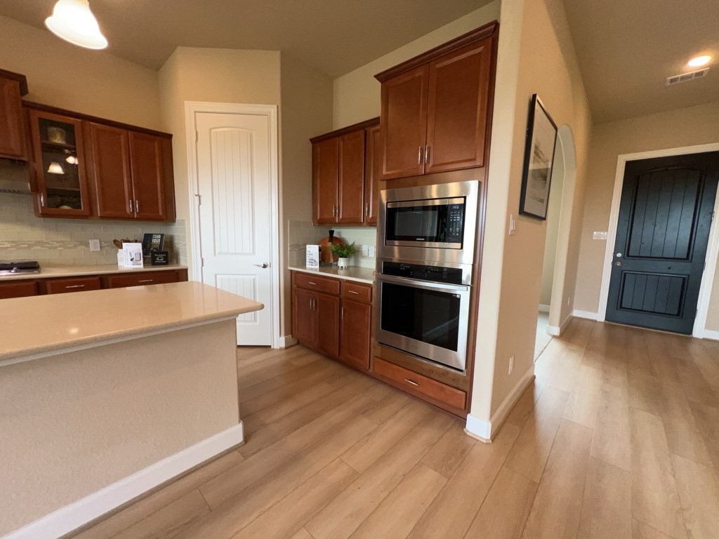 5602 Caracara Street Manvel, TX 77578 - Photo 10 of 27 a kitchen with stainless steel appliances a refrigerator and a stove top oven