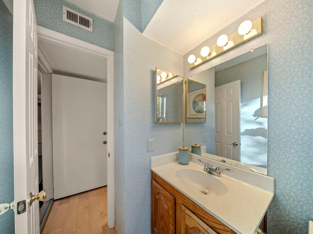 13347 Pandora Circle Dallas, TX 75238 - Photo 14 of 36 a bathroom with a sink vanity and a mirror