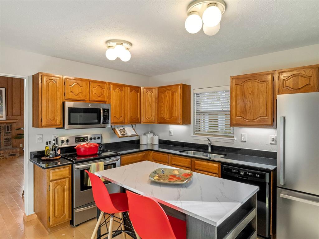 13347 Pandora Circle Dallas, TX 75238 - Photo 16 of 36 a kitchen with a stove a sink and a refrigerator