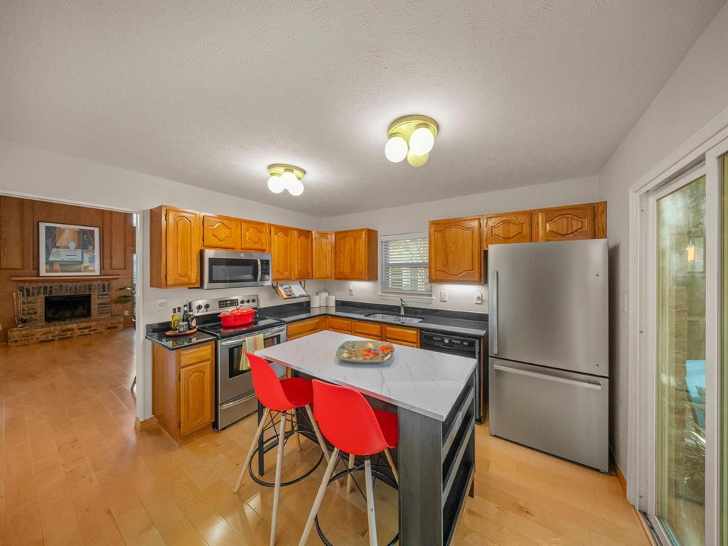 13347 Pandora Circle Dallas, TX 75238 - Photo 5 of 36 a kitchen with a stove a refrigerator and a dining table