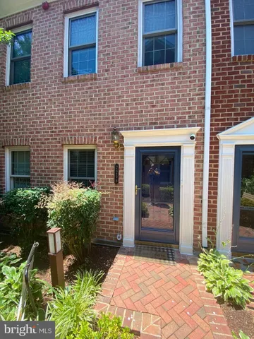 a stone house with potted plants in front of door