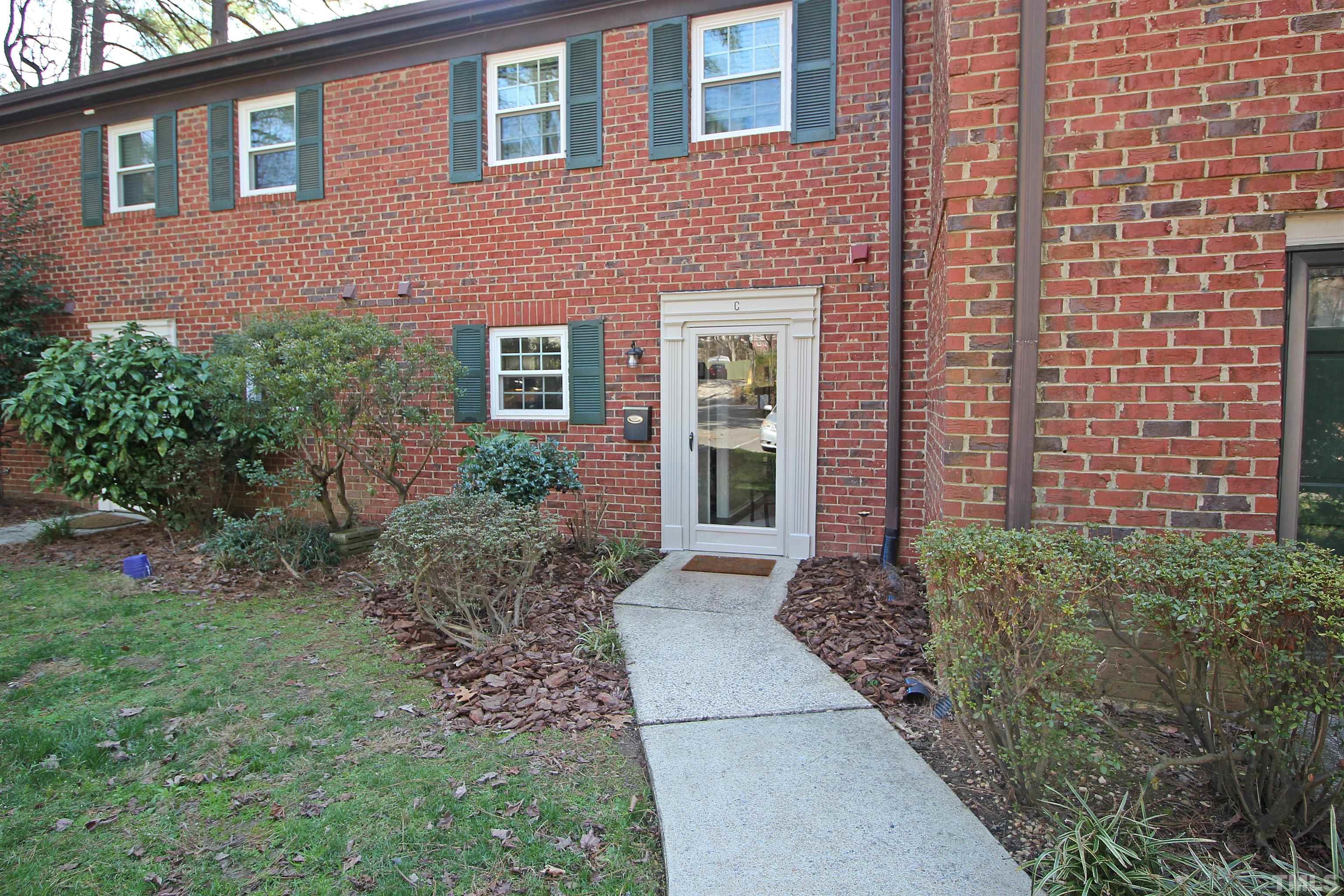 1204 Falls Church Road, Unit C Raleigh, NC 27609 - Photo 1 of 26 a view of a brick house with a yard and plants