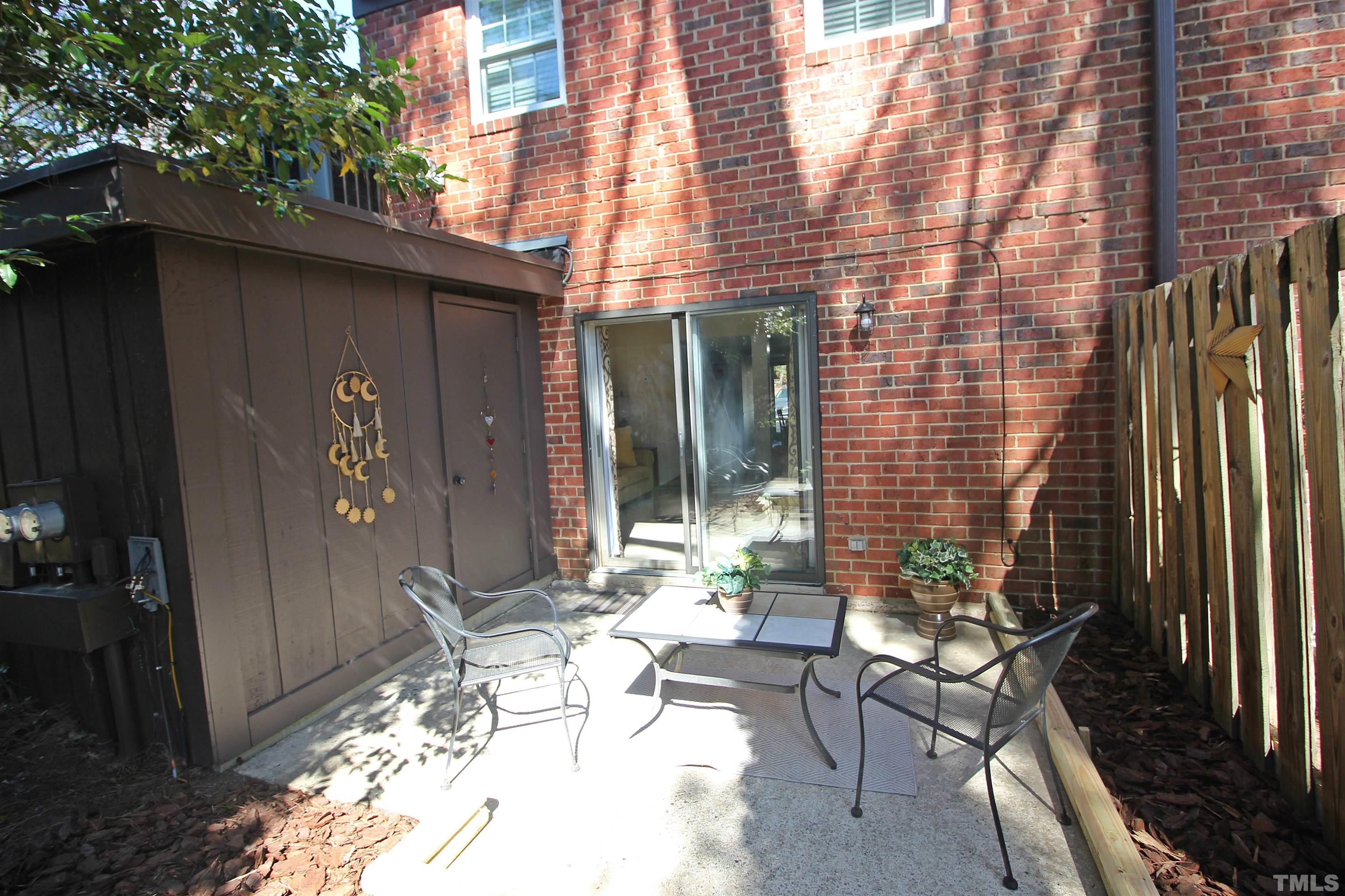 1204 Falls Church Road, Unit C Raleigh, NC 27609 - Photo 24 of 26 a patio with table and chairs and potted plants