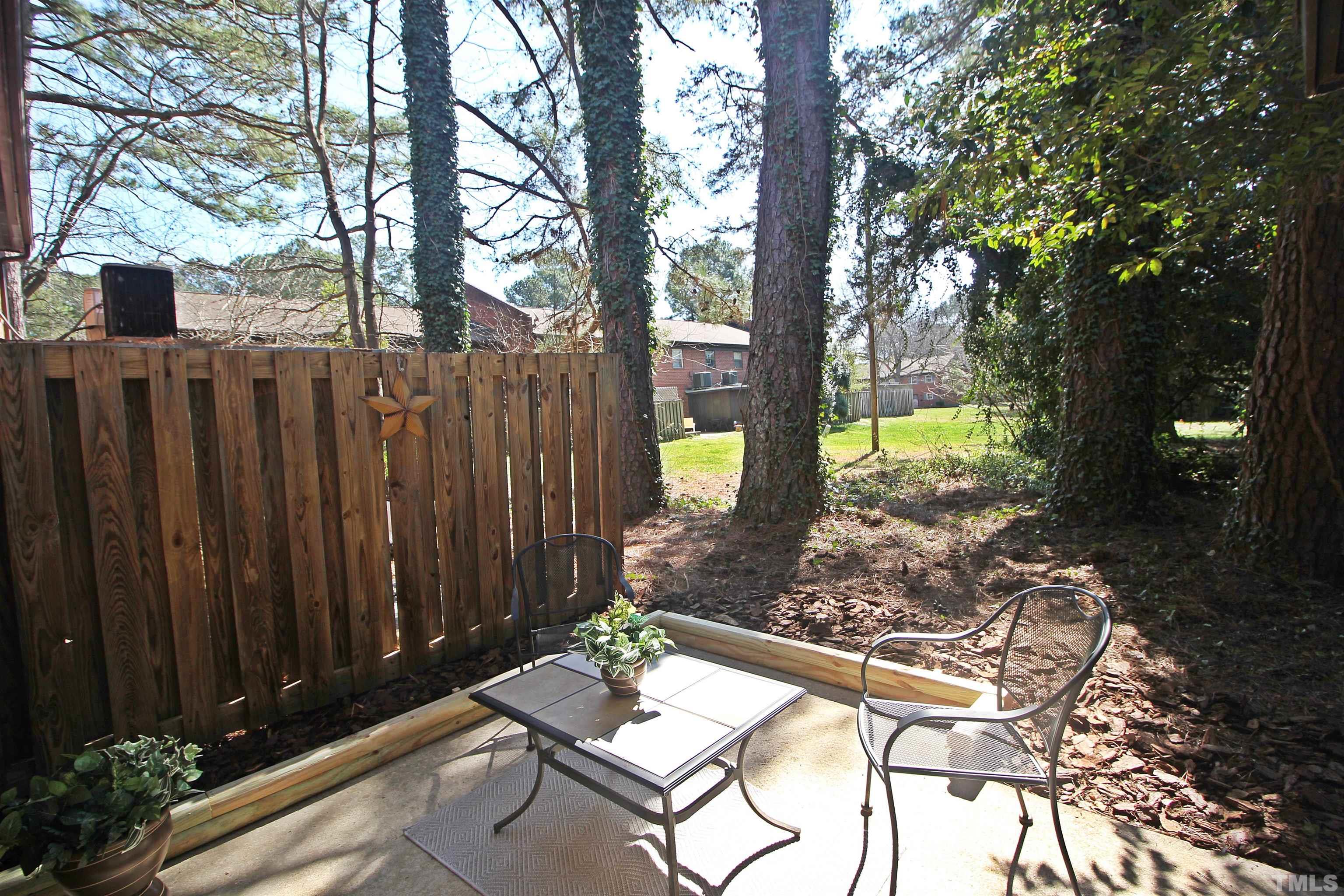 1204 Falls Church Road, Unit C Raleigh, NC 27609 - Photo 25 of 26 a view of backyard with a table and chairs and wooden fence