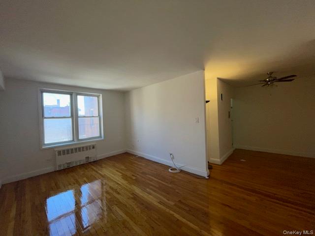 62-59 108th Street, Unit 5C Queens, NY 11375 - Photo 3 of 8 an empty room with wooden floor and windows