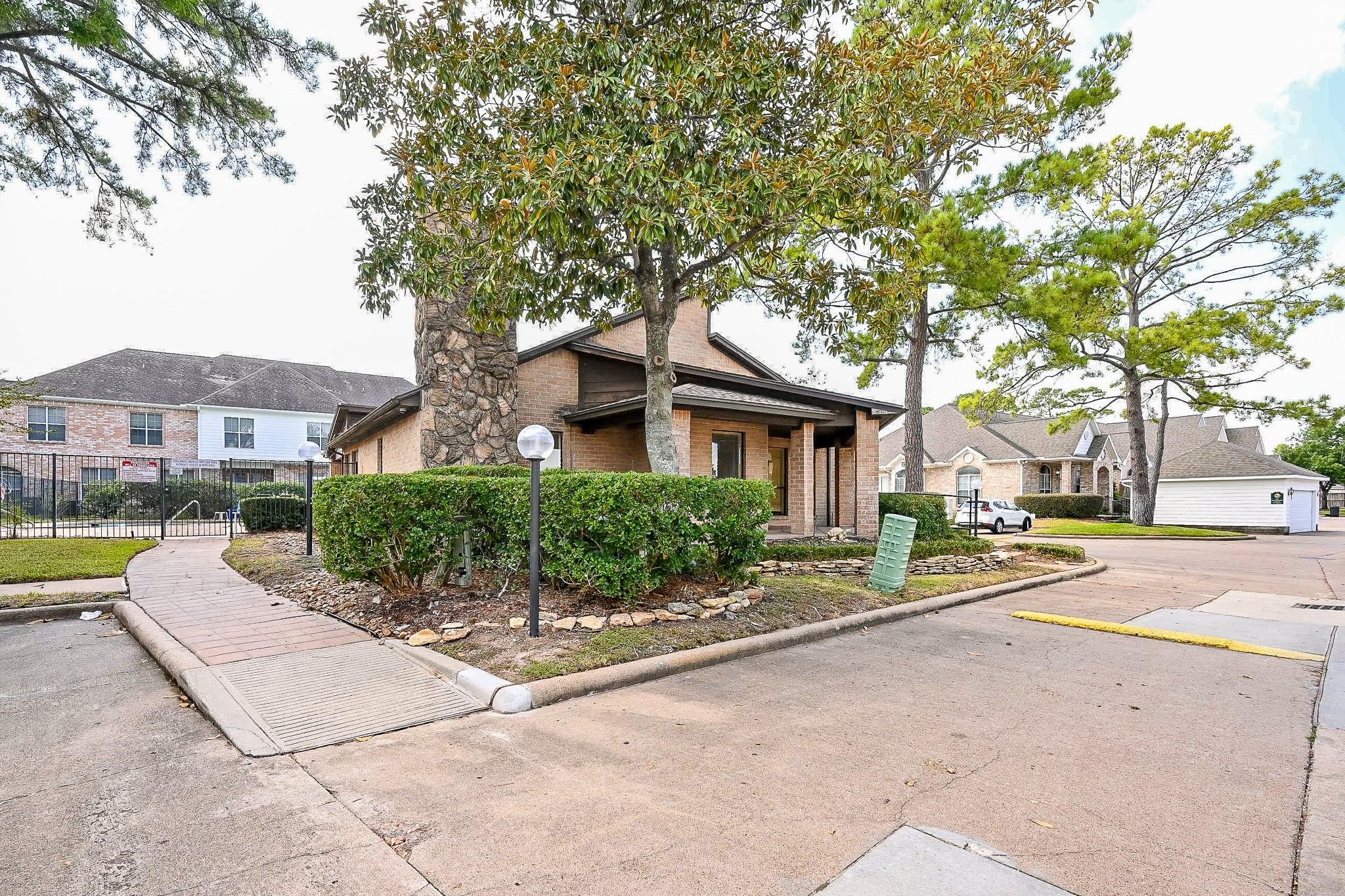 12755 Mill Ridge Drive, Unit 217 Cypress, TX 77429 - Photo 11 of 17 a front view of a house with a garden and trees