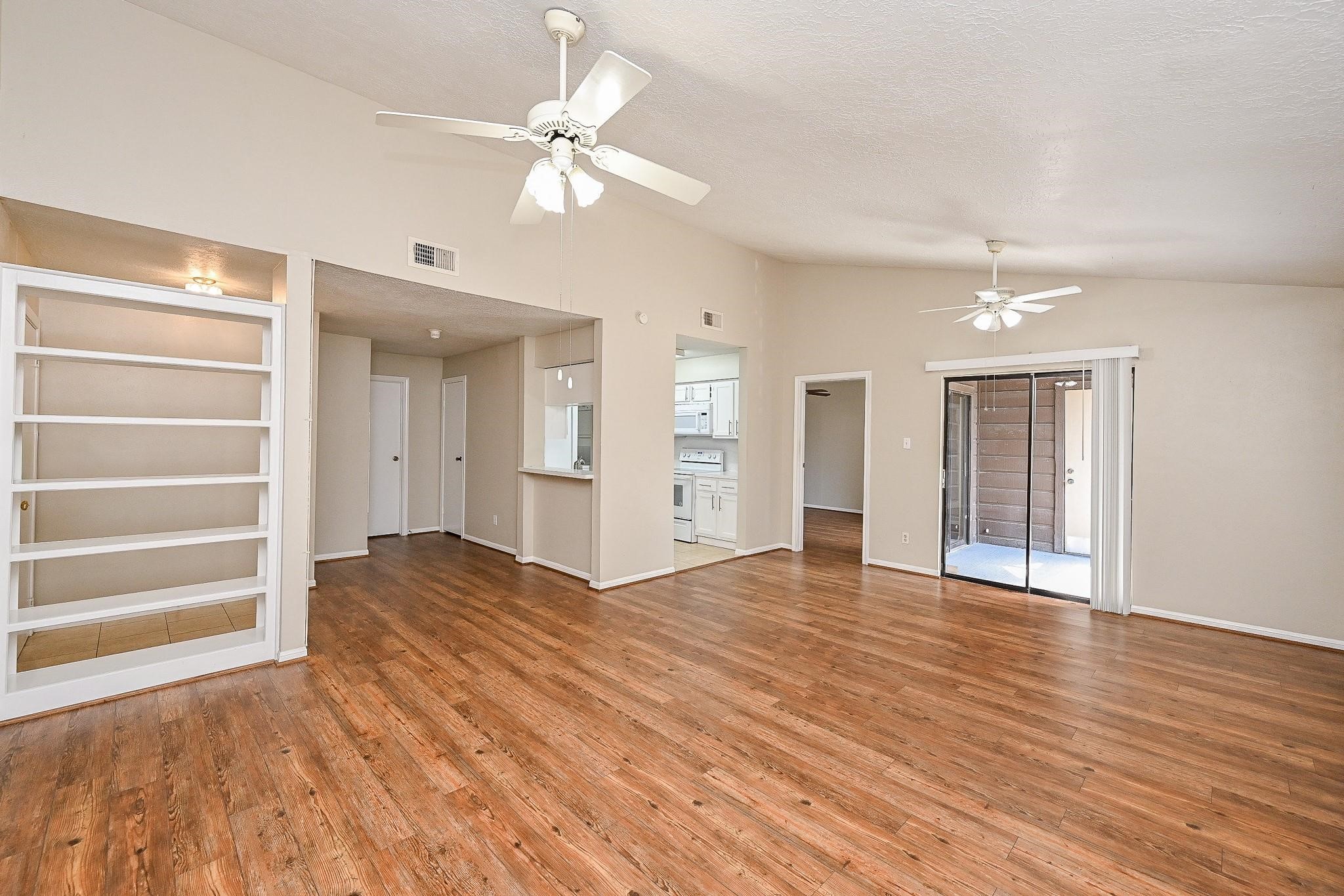 12755 Mill Ridge Drive, Unit 217 Cypress, TX 77429 - Photo 3 of 17 a view of an empty room with a window and wooden floor