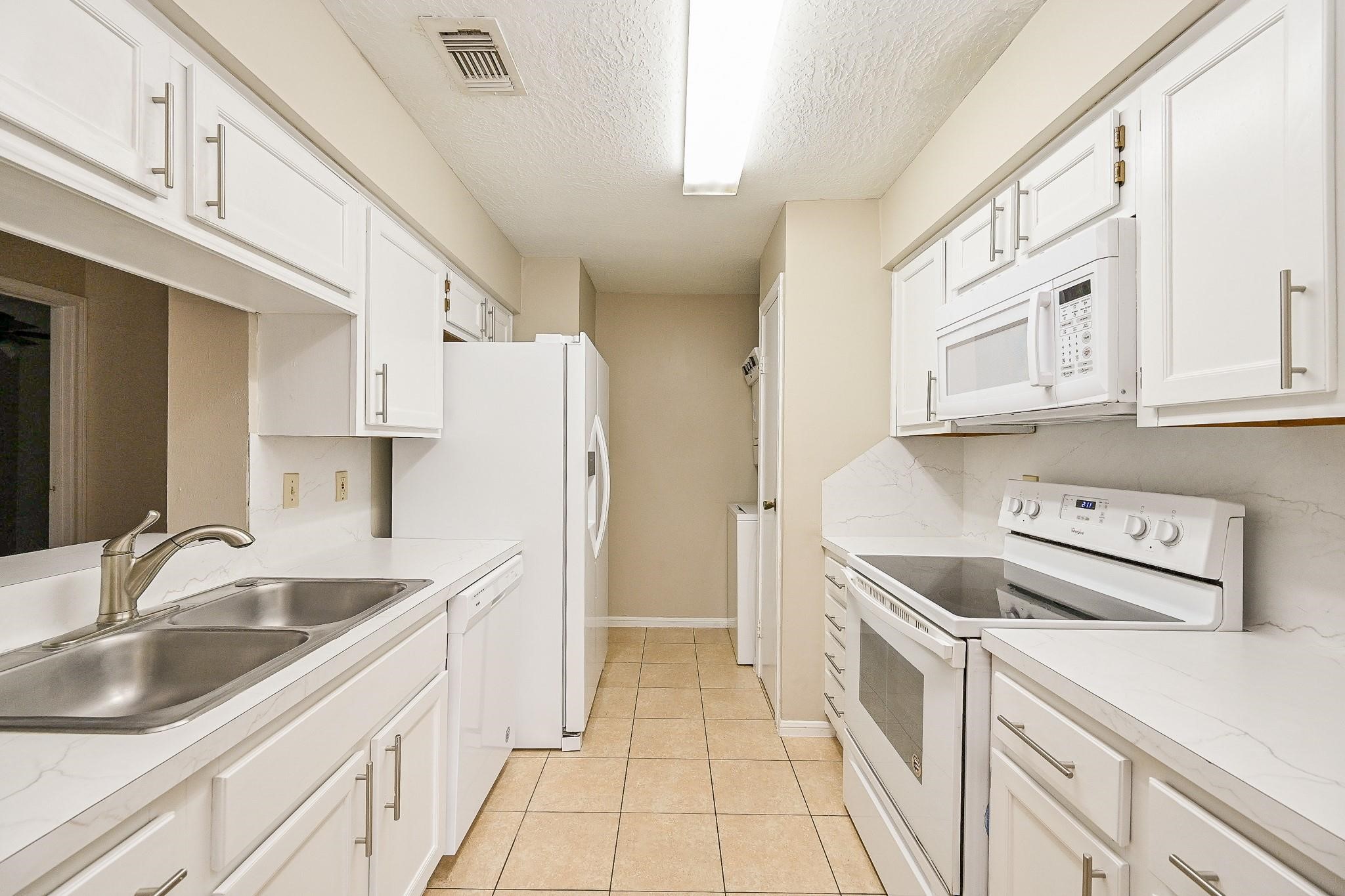 12755 Mill Ridge Drive, Unit 217 Cypress, TX 77429 - Photo 4 of 17 a kitchen with a sink a stove and refrigerator