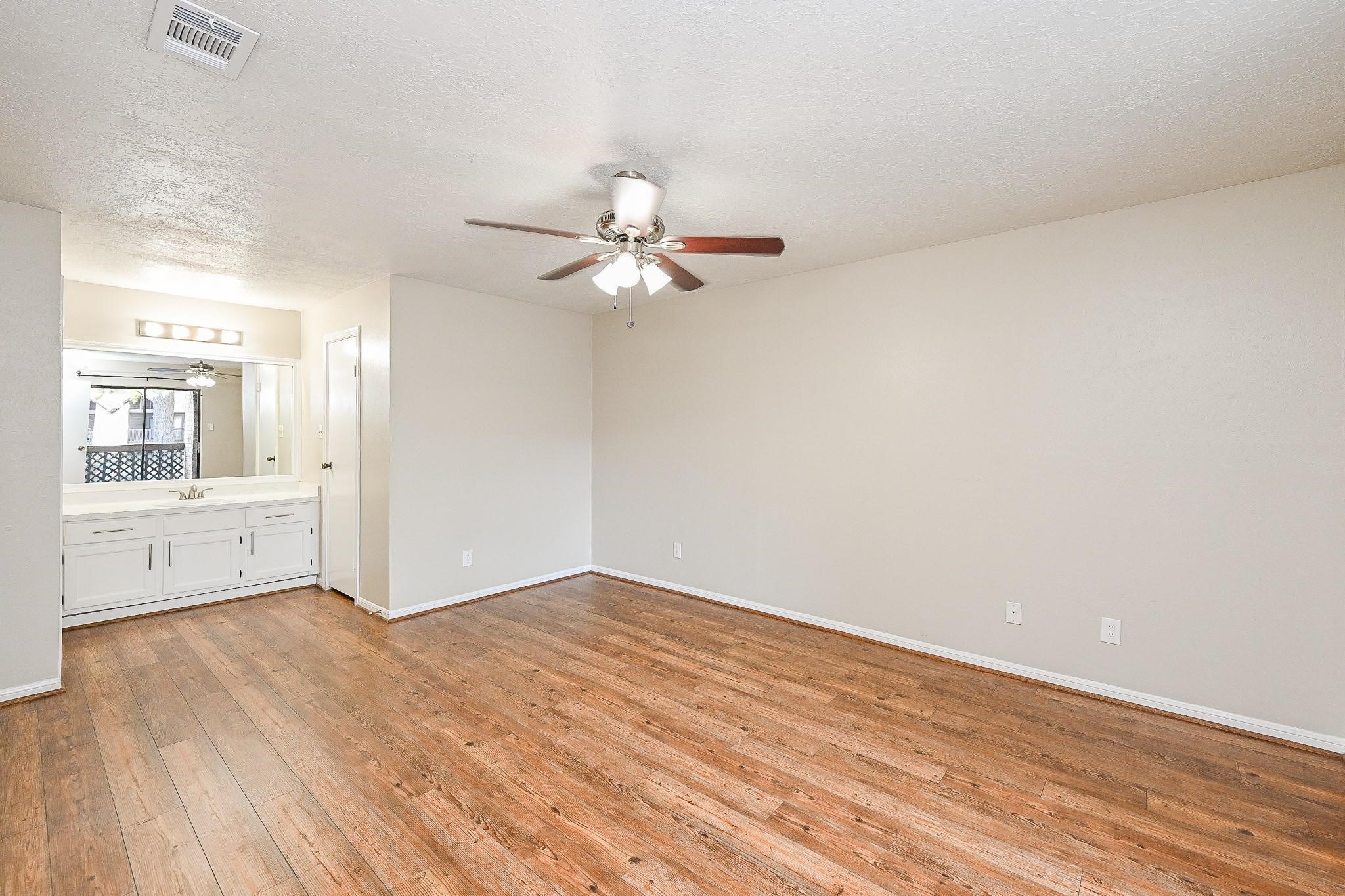 12755 Mill Ridge Drive, Unit 217 Cypress, TX 77429 - Photo 6 of 17 wooden floor in an empty room with a window