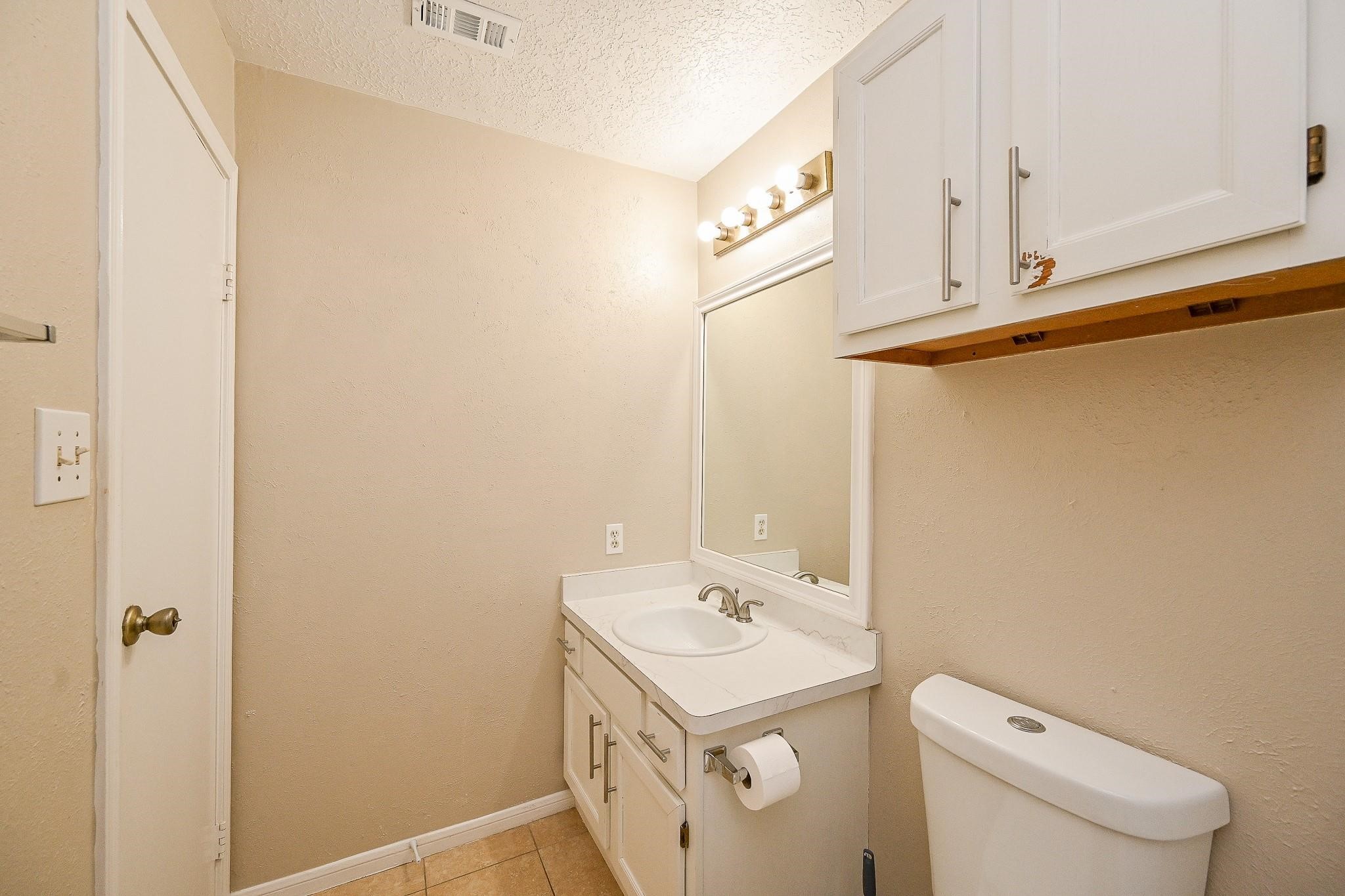 12755 Mill Ridge Drive, Unit 217 Cypress, TX 77429 - Photo 9 of 17 a bathroom with a sink a toilet and vanity