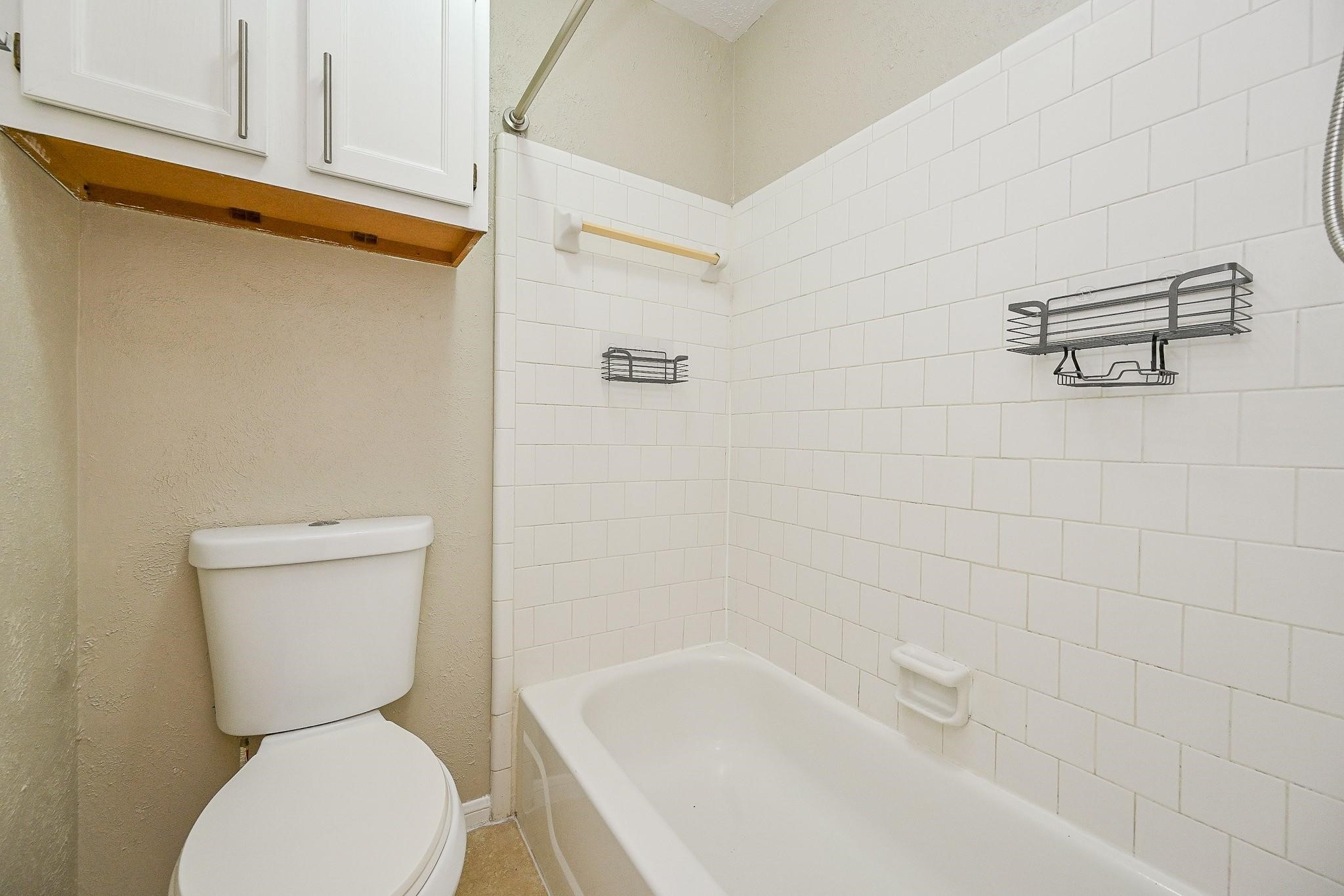 12755 Mill Ridge Drive, Unit 217 Cypress, TX 77429 - Photo 10 of 17 a bathroom with a toilet and bathtub
