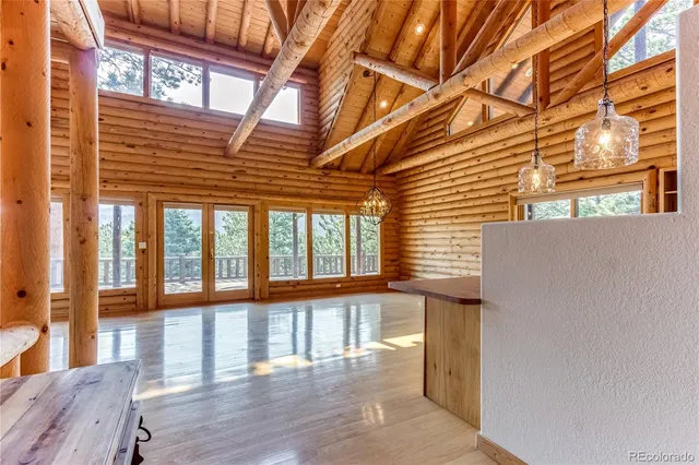a view of a large room with wooden floor and windows