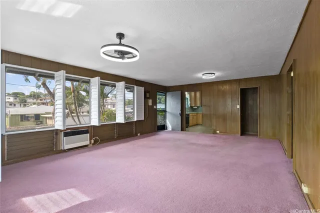 a big room with windows and view of kitchen