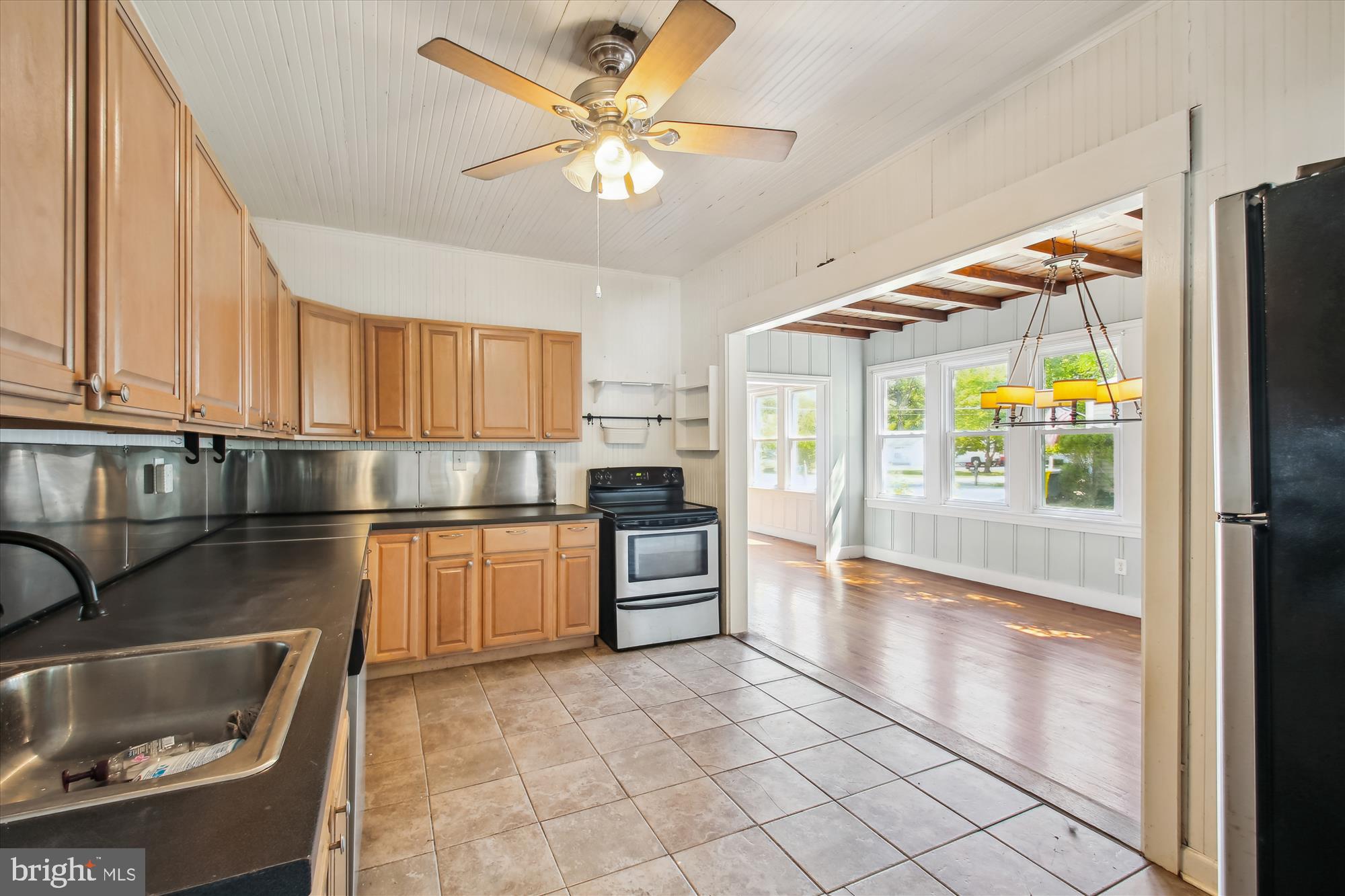 611 Clark Avenue Deale, MD 20751 - Photo 22 of 37 a kitchen with granite countertop a refrigerator a stove a sink and a dining table with wooden floor