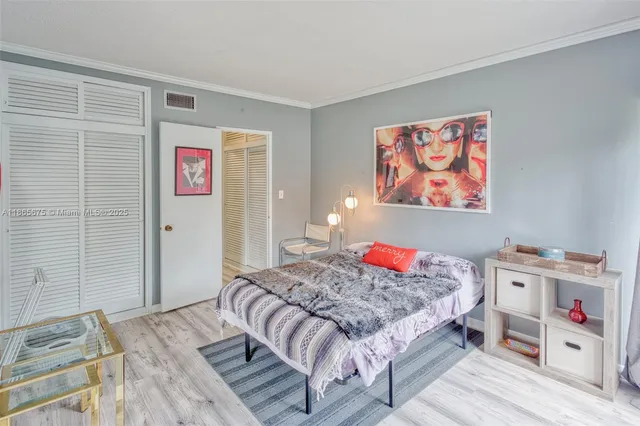a bedroom with a bed and a large mirror next to a window