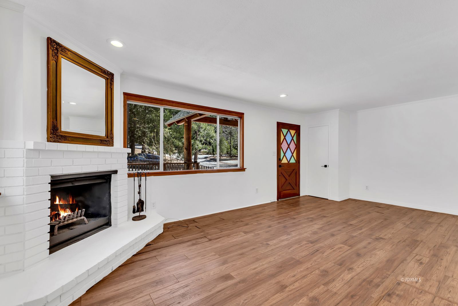 25459 Palomar Road Idyllwild, CA 92549 - Photo 13 of 51 a view of an empty room with wooden floor fireplace and a window