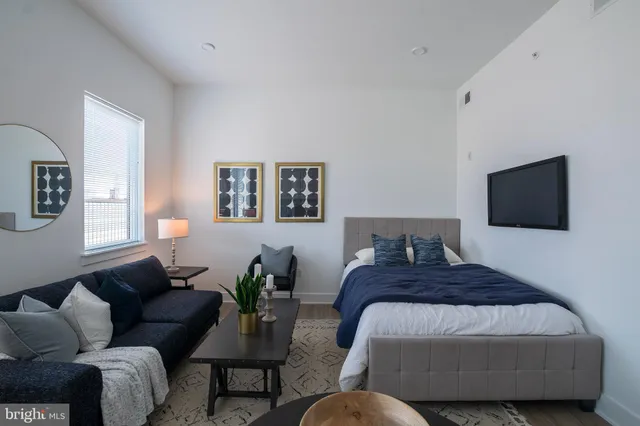 a bedroom with a bed couch and window