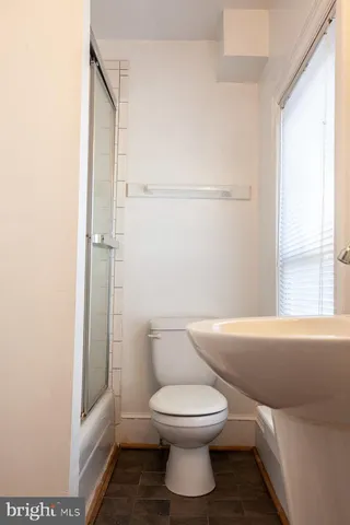 a white toilet sitting next to a bathroom sink