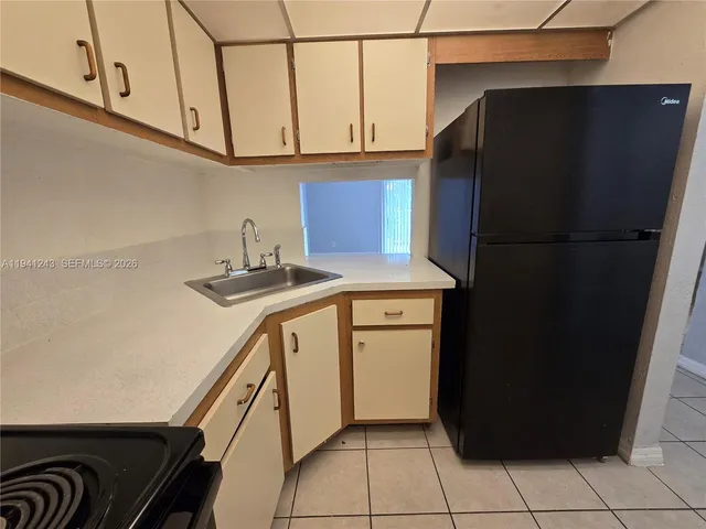 a kitchen with a refrigerator and a sink