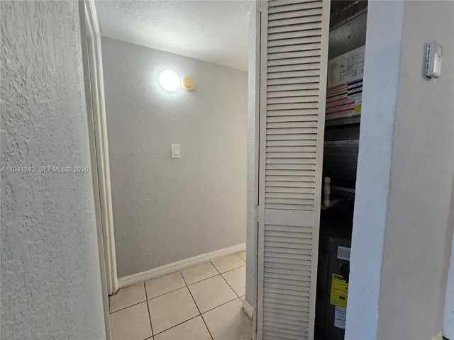 a view of an empty room with a chandelier fan