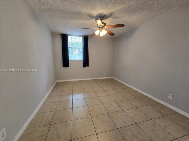 a view of an empty room and chandelier fan