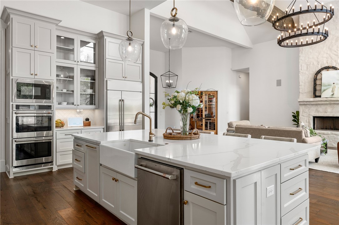 1351 River Road Waco, TX 76705 - Photo 14 of 96 a kitchen with a sink dishwasher a stove and a refrigerator with wooden floor