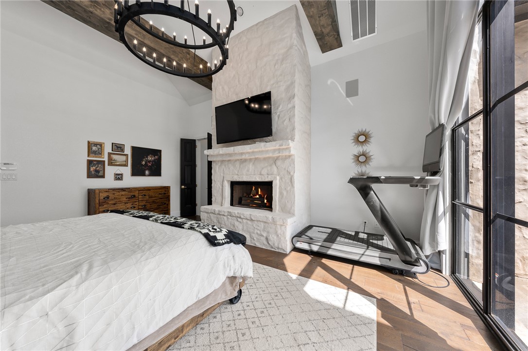 1351 River Road Waco, TX 76705 - Photo 22 of 96 a bedroom with a bed a flat screen tv and a fireplace