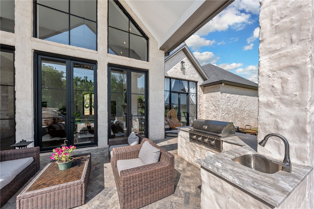 1351 River Road Waco, TX 76705 - Photo 52 of 96 a kitchen with granite countertop a sink and white cabinets next to a window